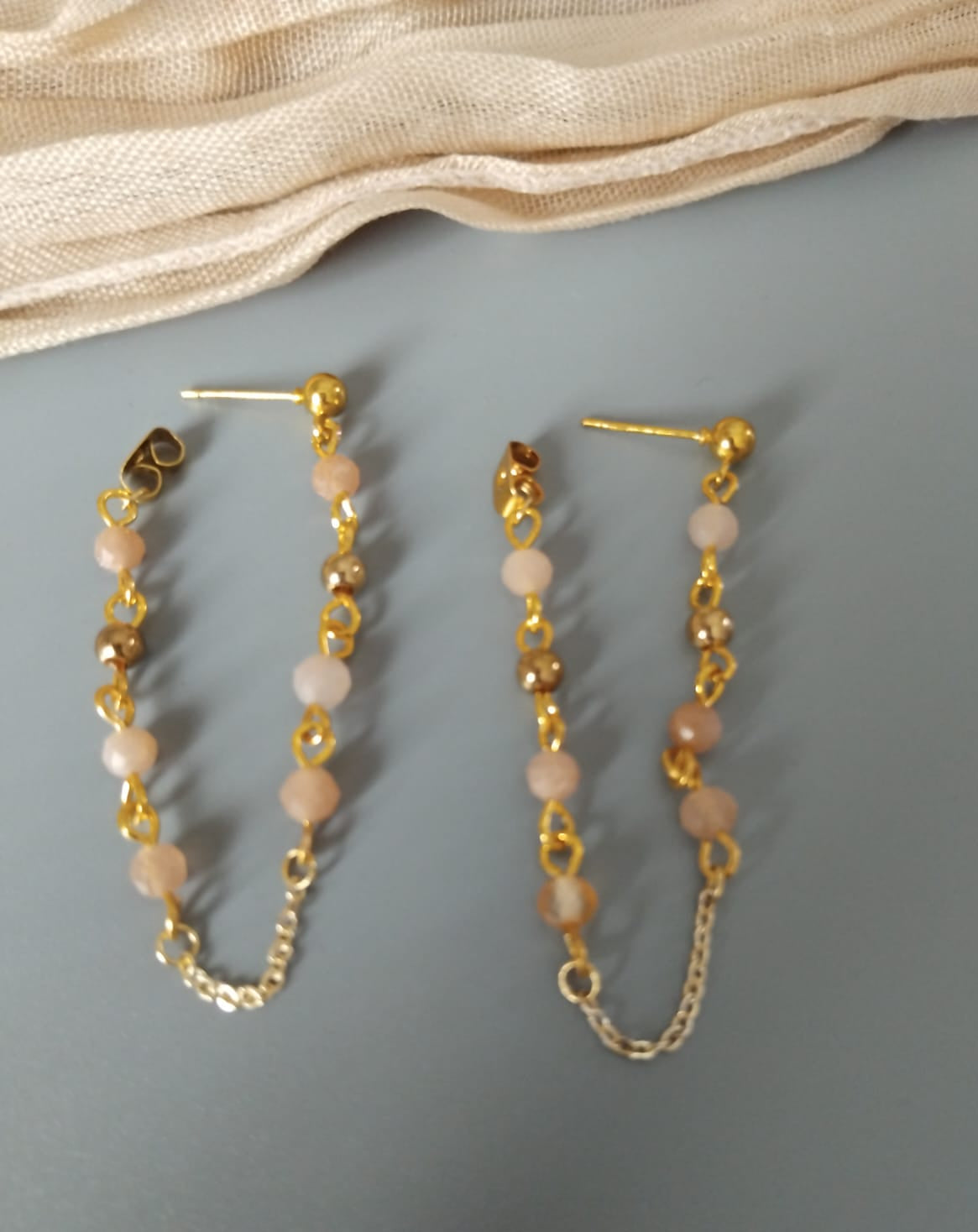 boucles en pierre de soleil et perles dorées reliées au papillon du clou