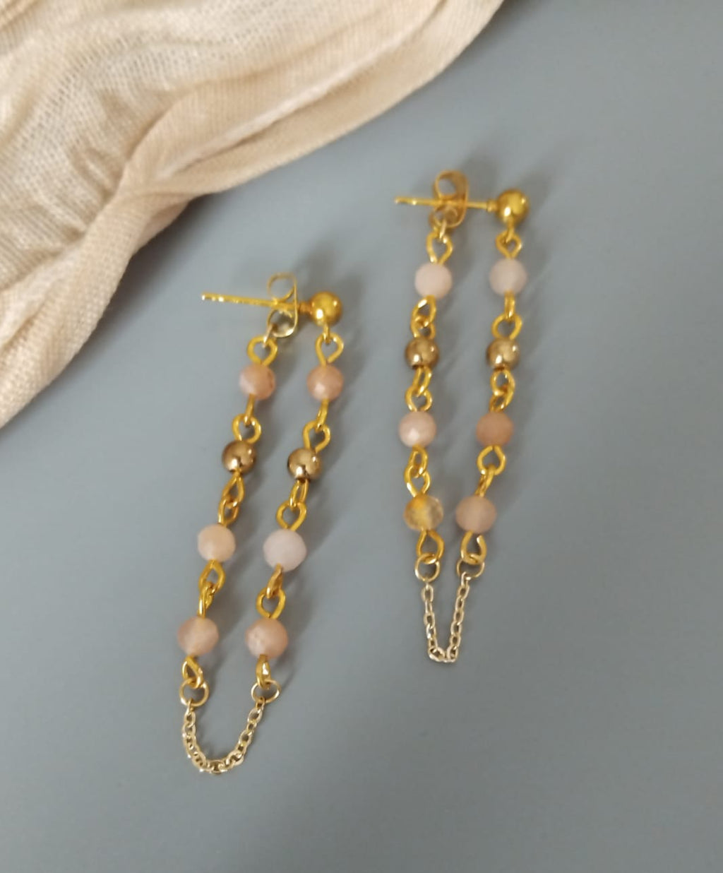 boucles en pierre de soleil et perles dorées reliées au papillon du clou