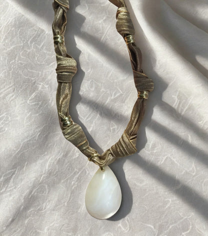 Collier Eloha noué à la main en tissu ocre satiné avec pendentif d’agate rayée naturelle. Bijou artisanal fait main, doux et chaleureux.