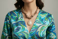 Collier Eloha noué à la main en tissu ocre satiné avec pendentif d’agate rayée naturelle. Bijou artisanal fait main, doux et chaleureux.