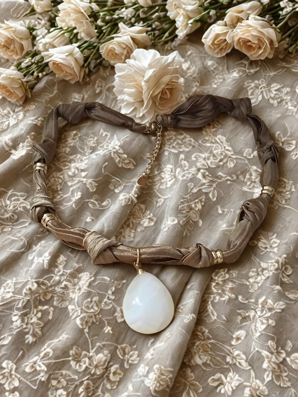 Collier Eloha noué à la main en tissu ocre satiné avec pendentif d’agate rayée naturelle. Bijou artisanal fait main, doux et chaleureux.